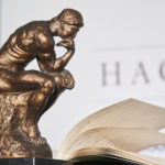bronze statue the thinker next to book