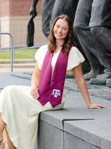 paige ripberger sitting in front of statues at Kyle Field