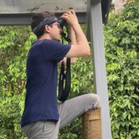 austen using binoculars in forest
