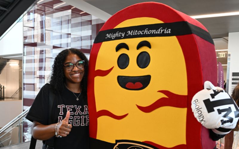 woman standing with mitochondria mascot